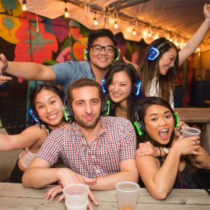Group of people at a bar wearing silent disco headphones
